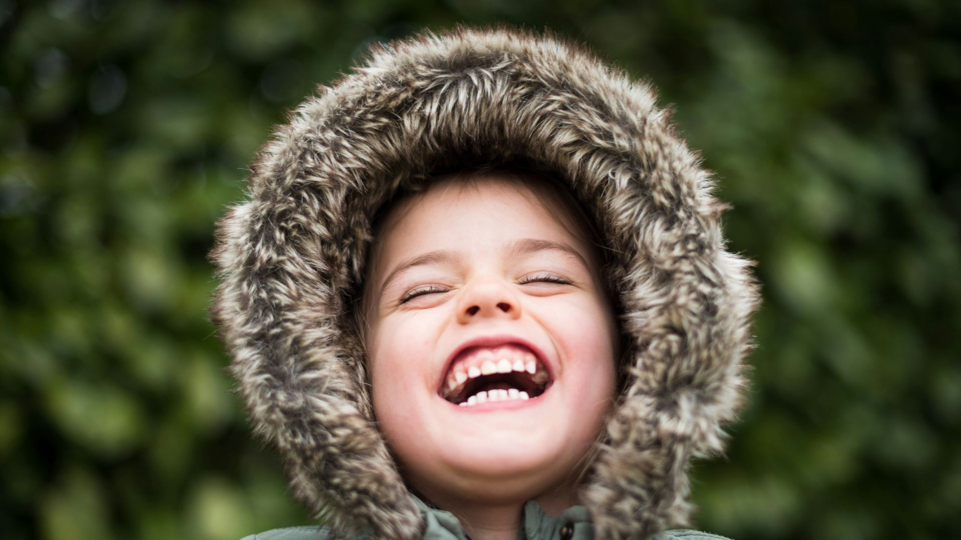selective focus photography of child laughing