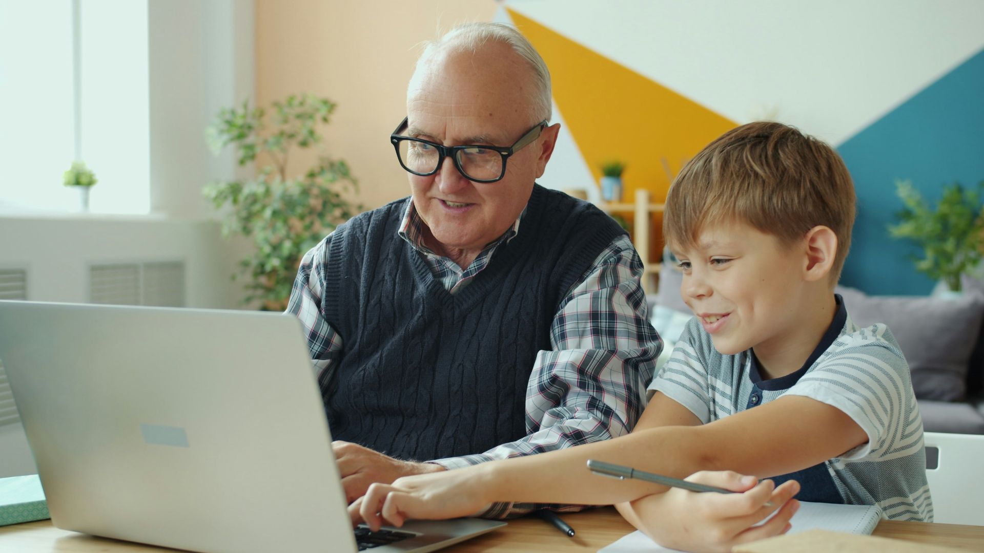 Grandfather and grandson looking at laptop together