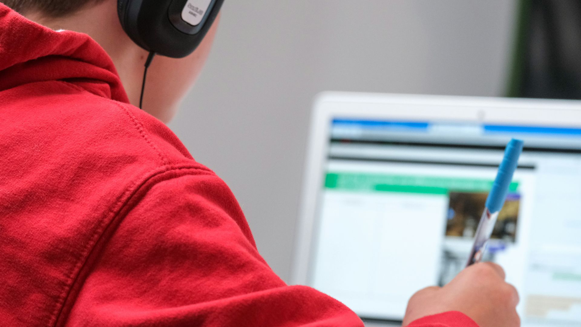 person in red shirt wearing black and gray headphones