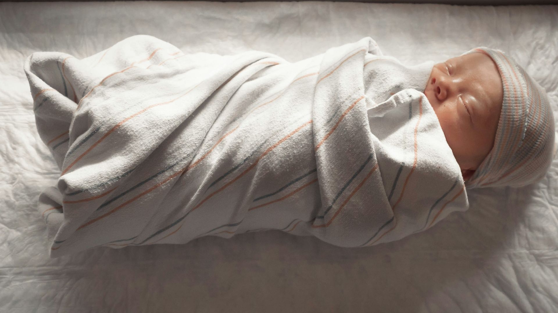 woman in white long sleeve shirt lying on bed