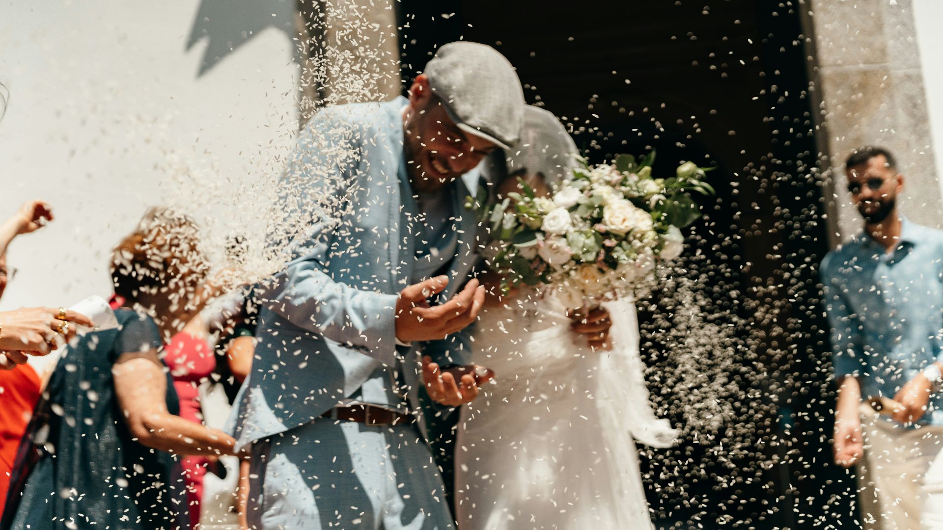 Newlyweds showered with confetti outside church.