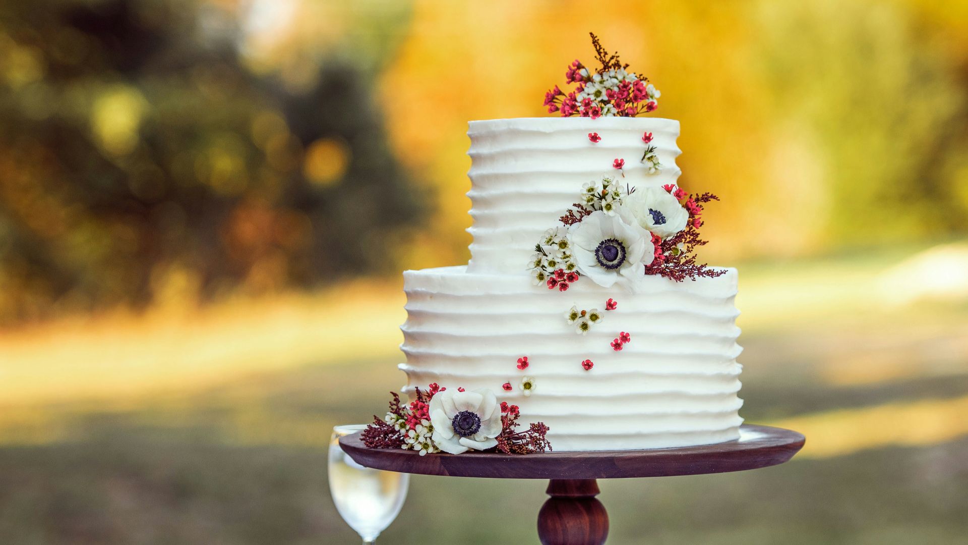 white and red floral cake on brown wooden stand