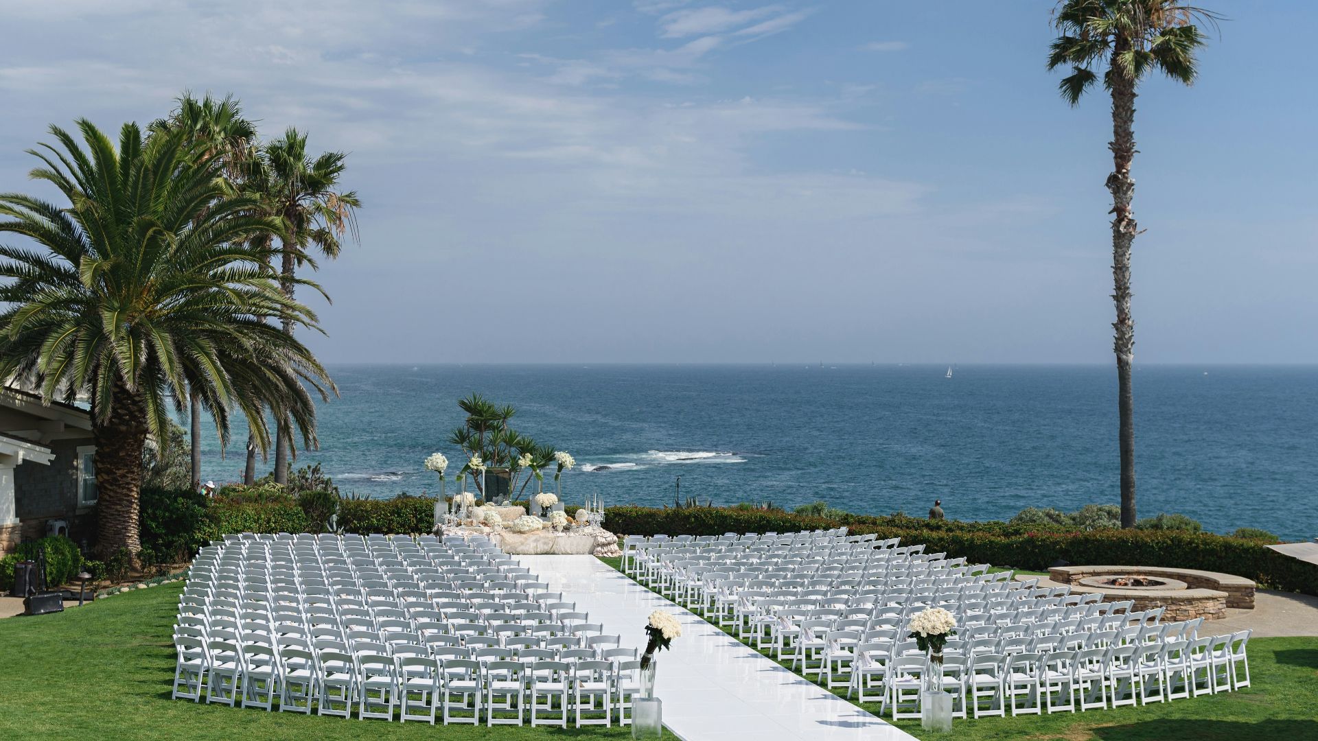 a wedding set up on a lawn overlooking the ocean