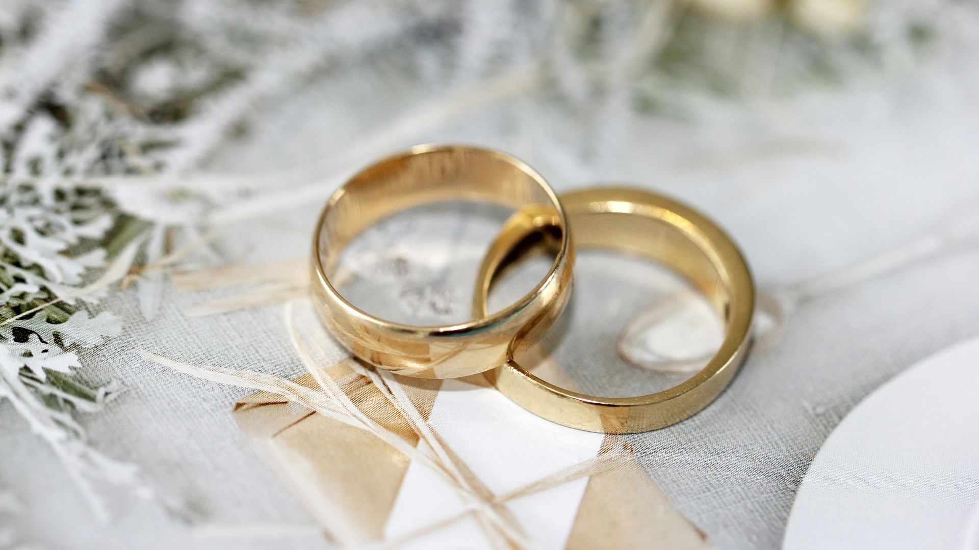 gold wedding band on white textile