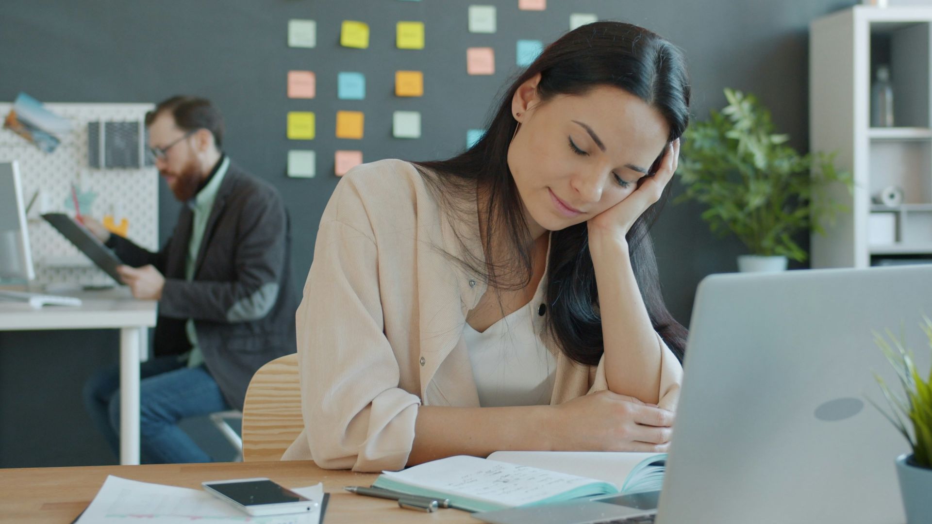 Woman resting head on hand at desk