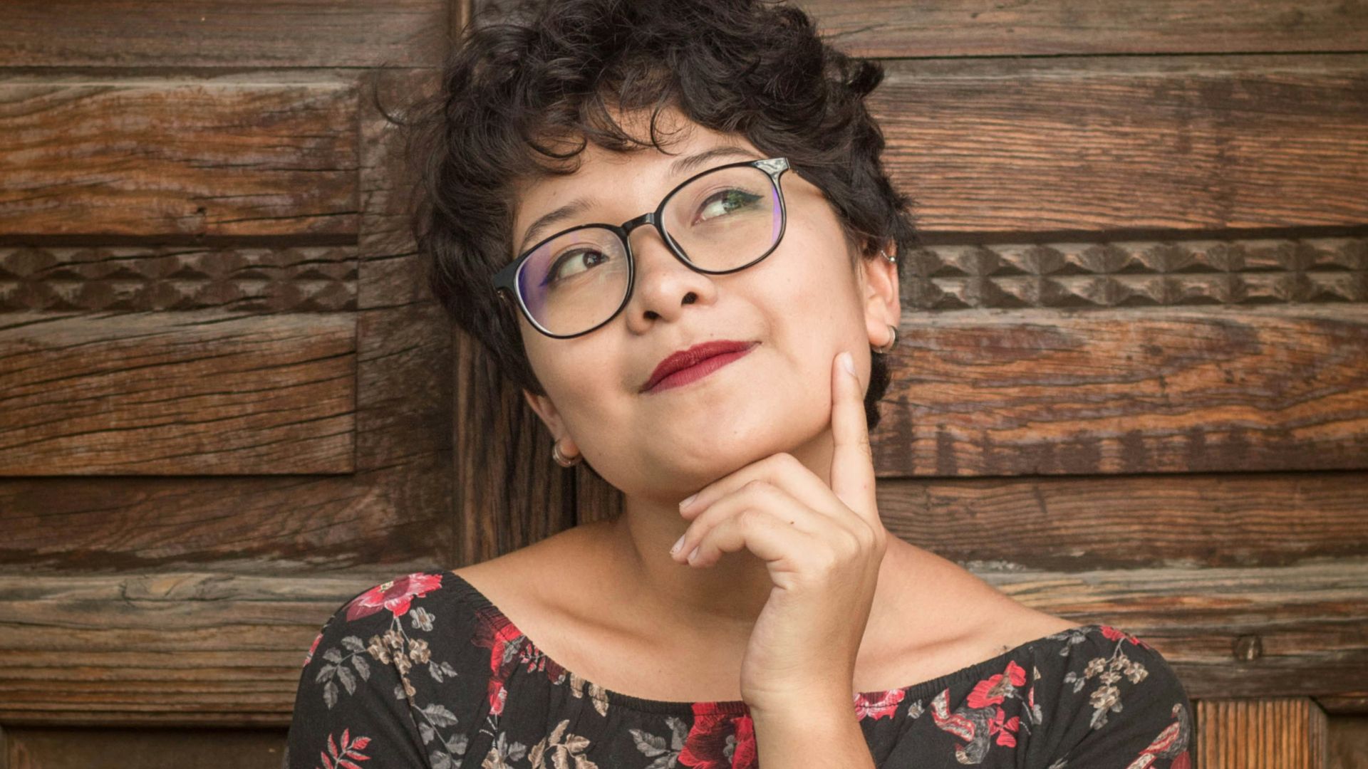 woman leaning against door while holding her cheek