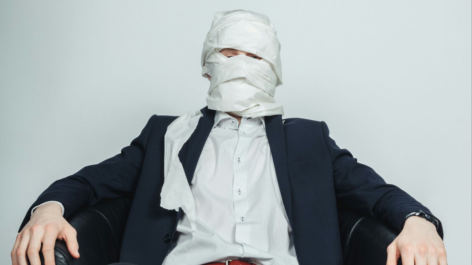 a man sitting in a chair with a mask on his face