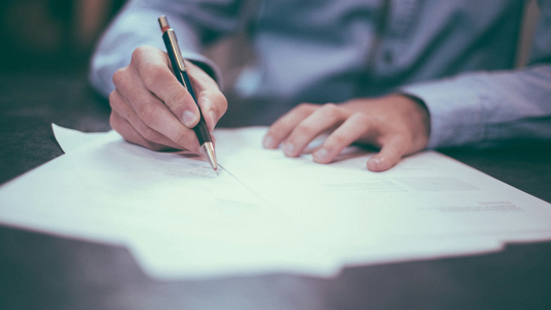 man writing on paper