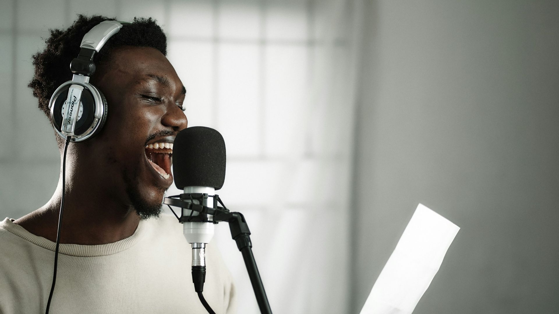 a man wearing headphones singing into a microphone