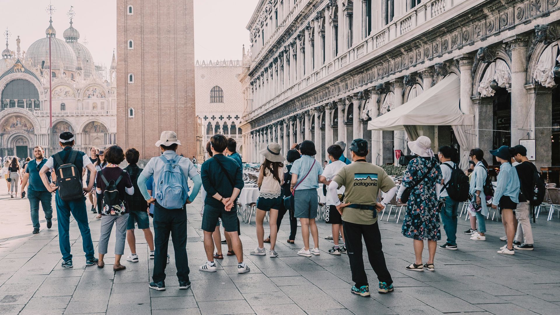 a group of people standing on a street next to a tall building