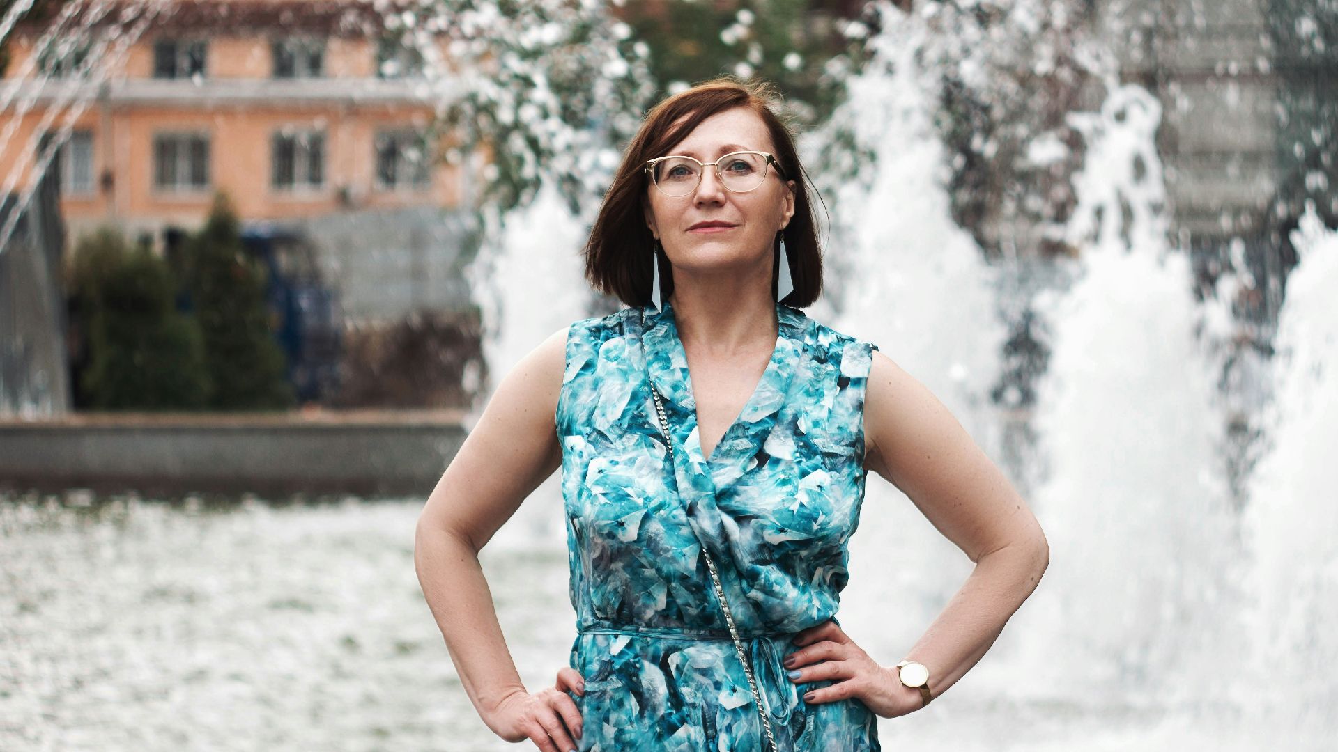 woman in blue and white floral sleeveless dress standing on snow covered ground during daytime