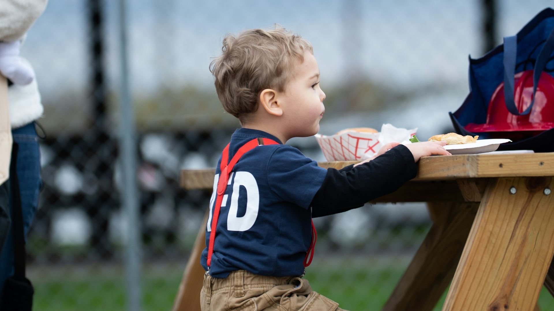 a little boy sitting at a picnic table