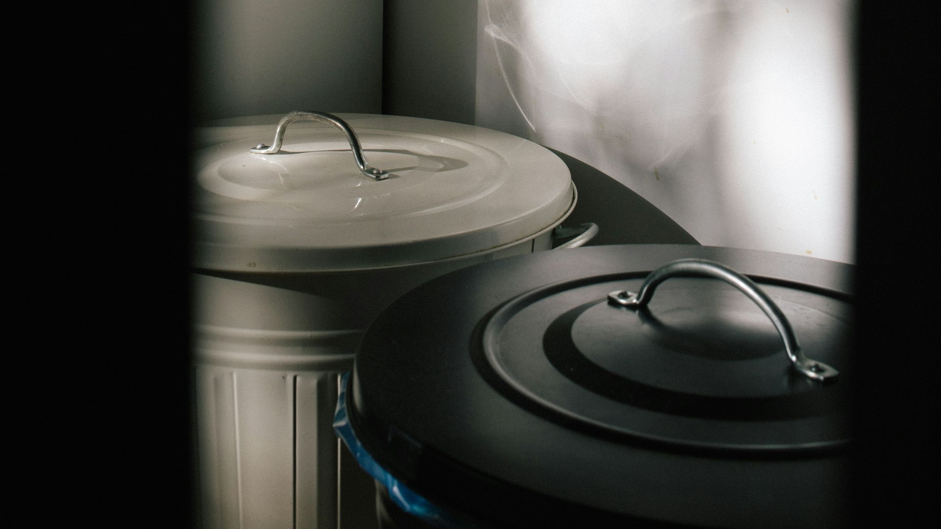 two trash cans inside dark room