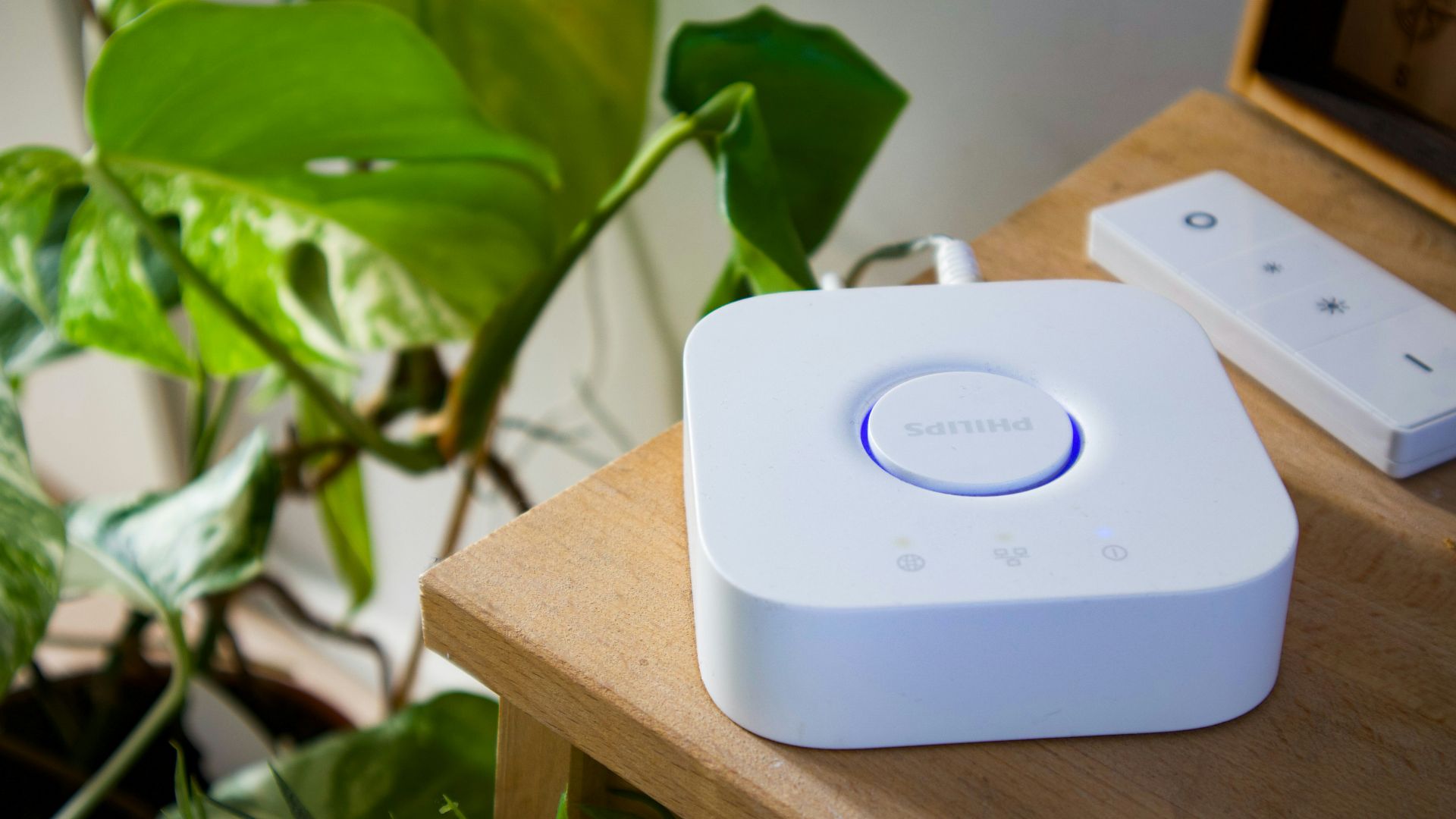 Smart home hub and remote on a wooden table.