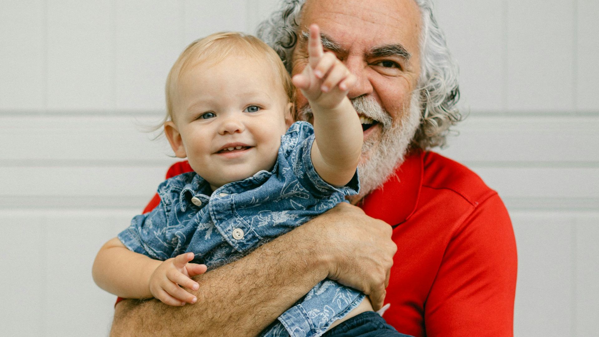 a man holding a baby in front of a garage door