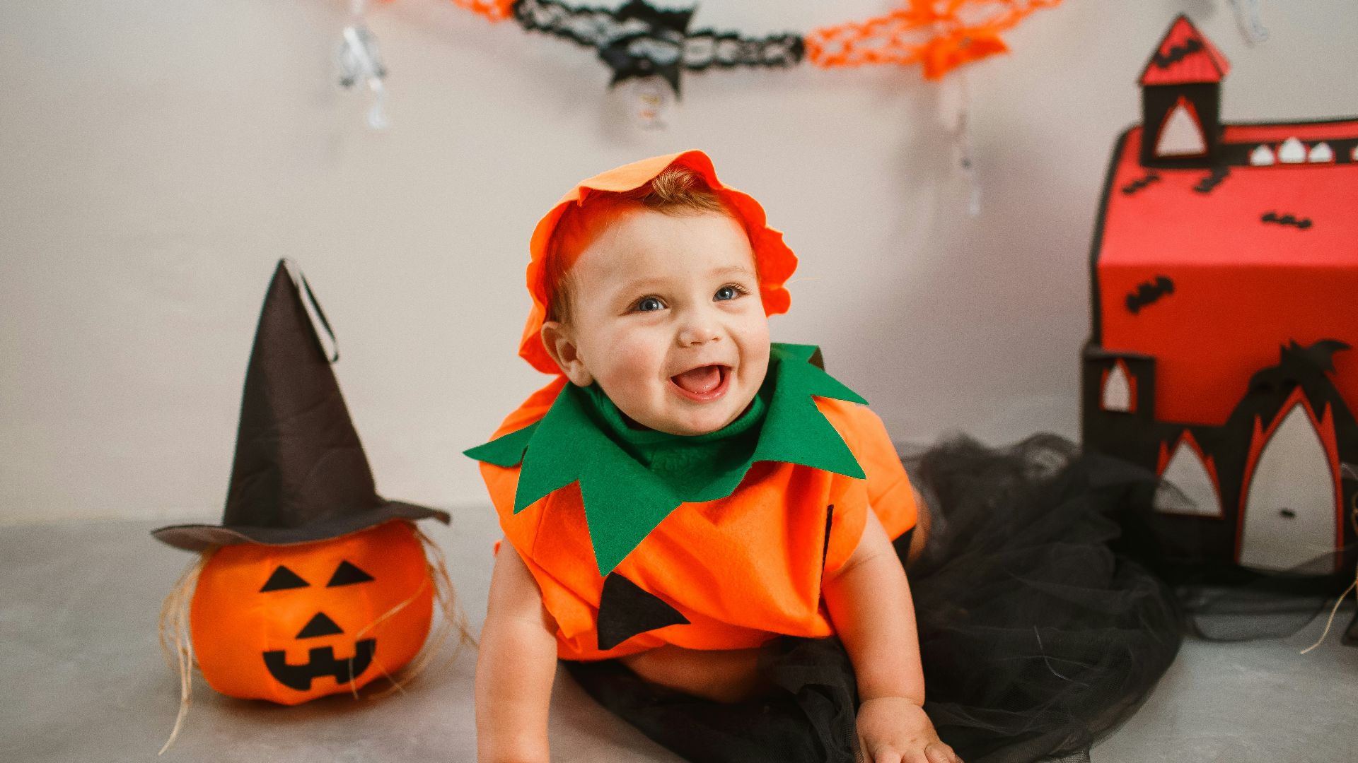 a baby in a halloween costume sitting on the floor