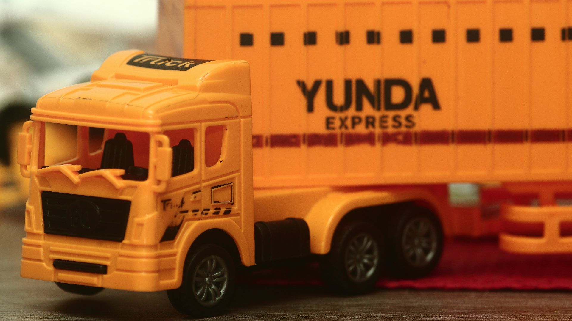 a yellow toy truck with a yellow trailer behind it