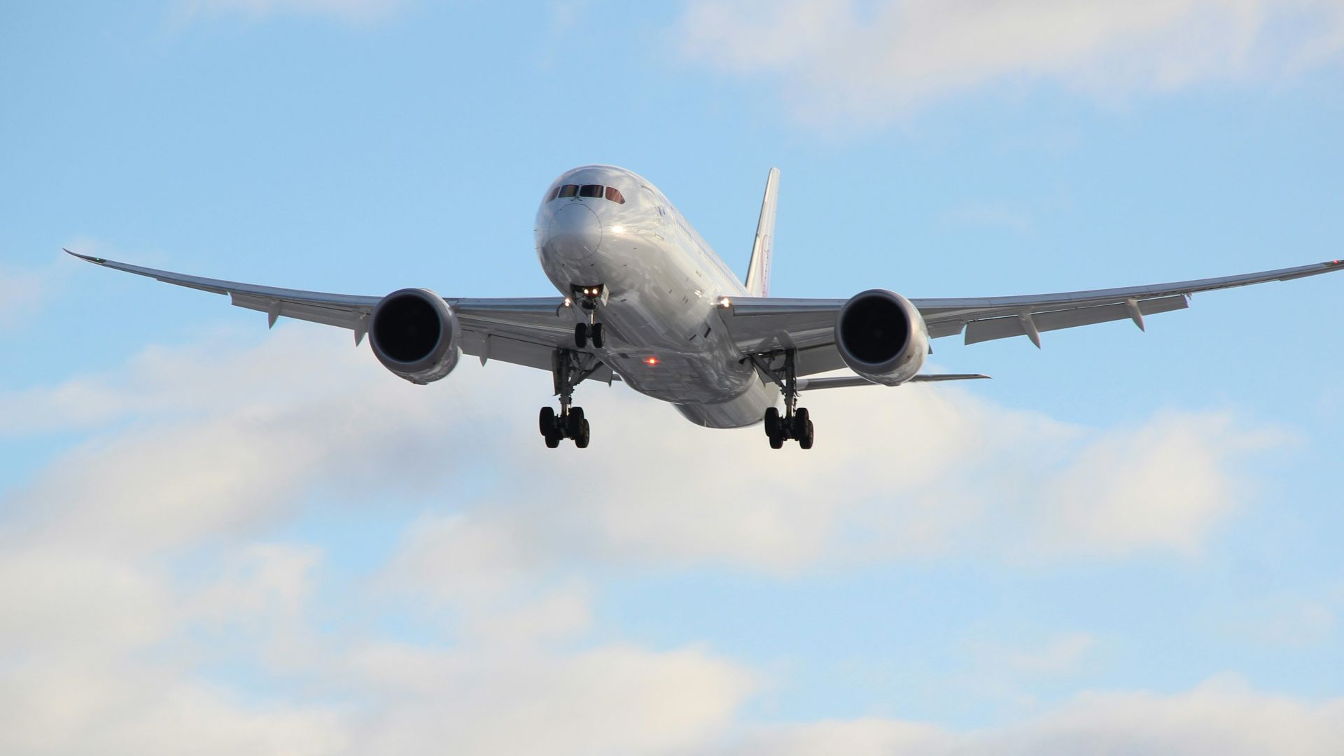white passenger plane in mid air during daytime