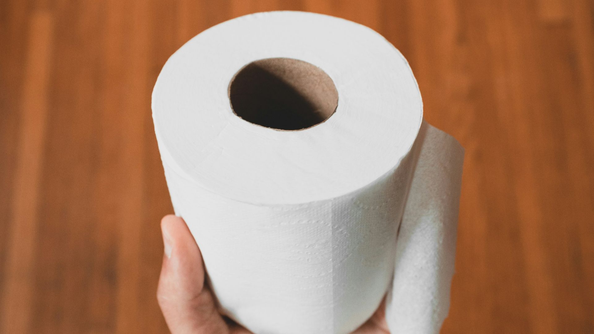 person holding white toilet paper roll