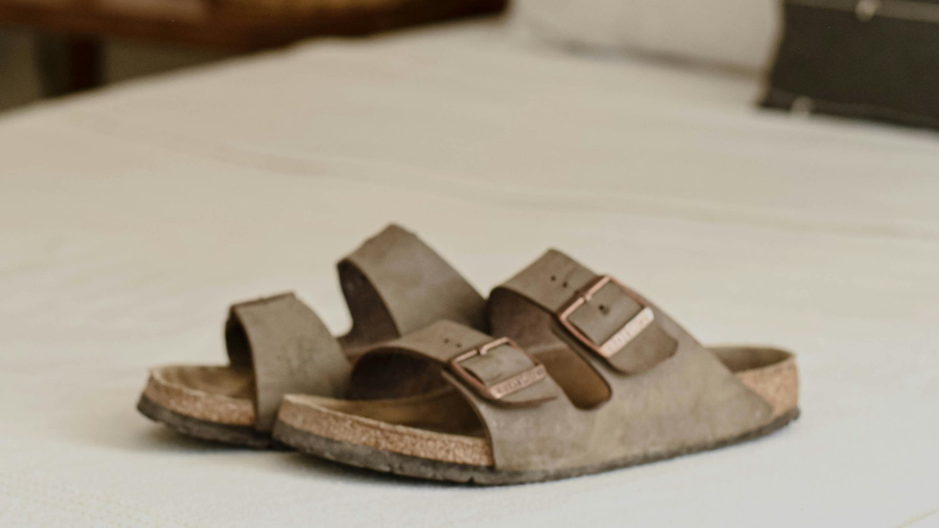 a pair of sandals sitting on top of a bed