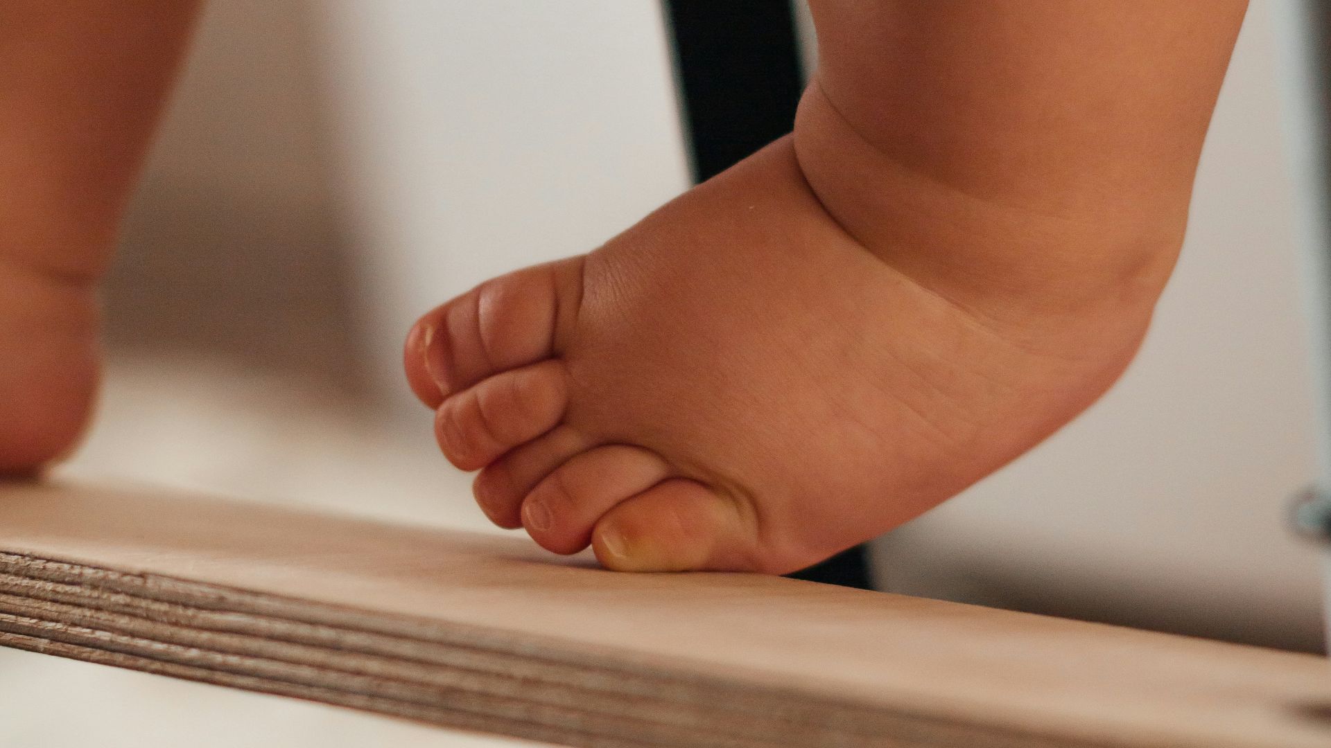 Close up of a baby's foot on a wooden surface