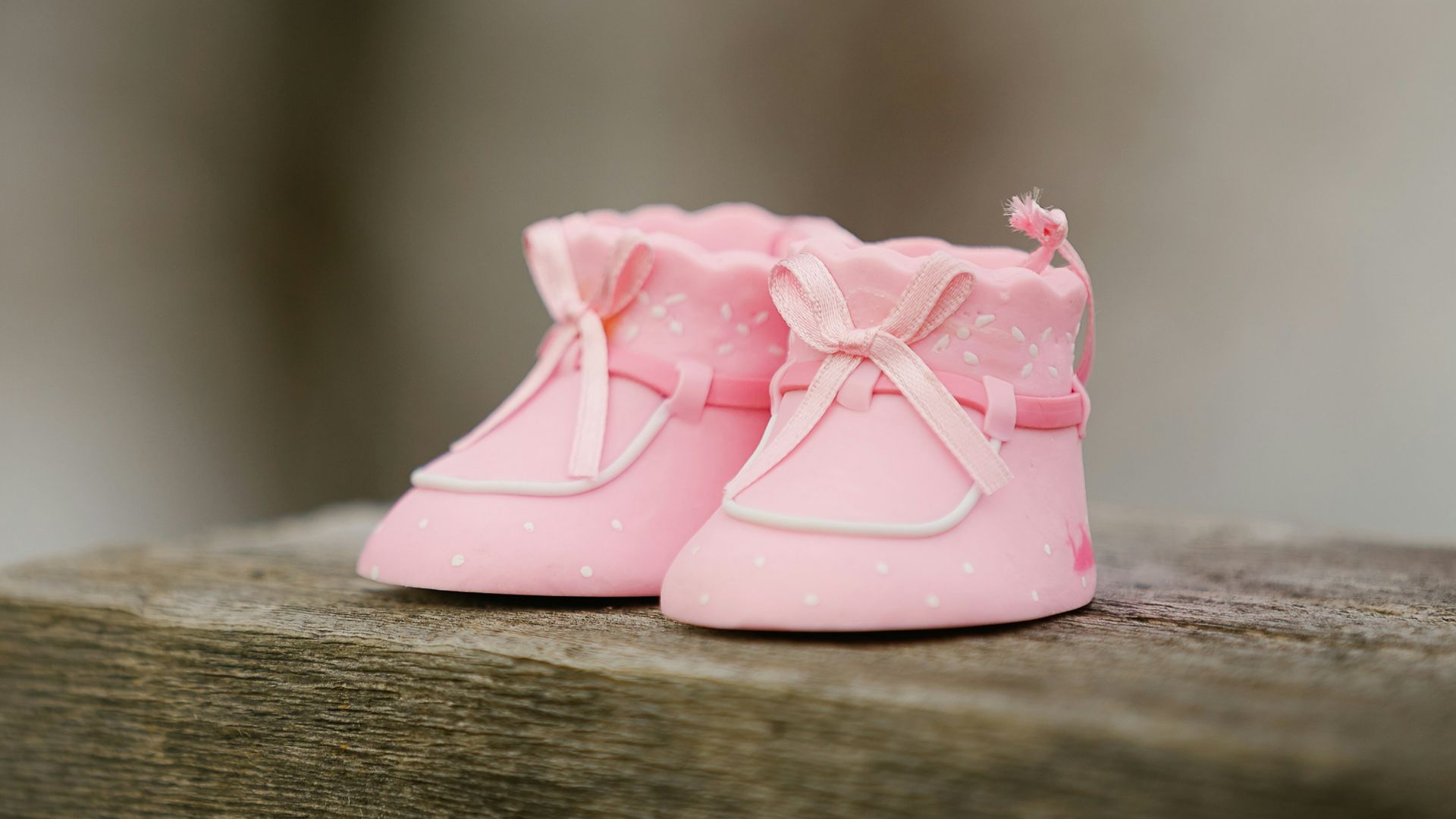 selective focus photography of pink shoes on wooden bench