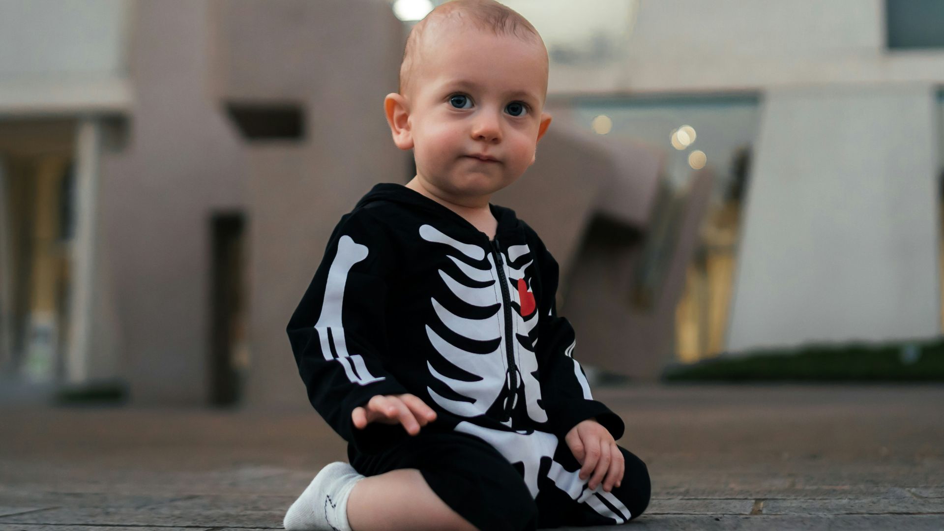 a baby sitting on a sidewalk