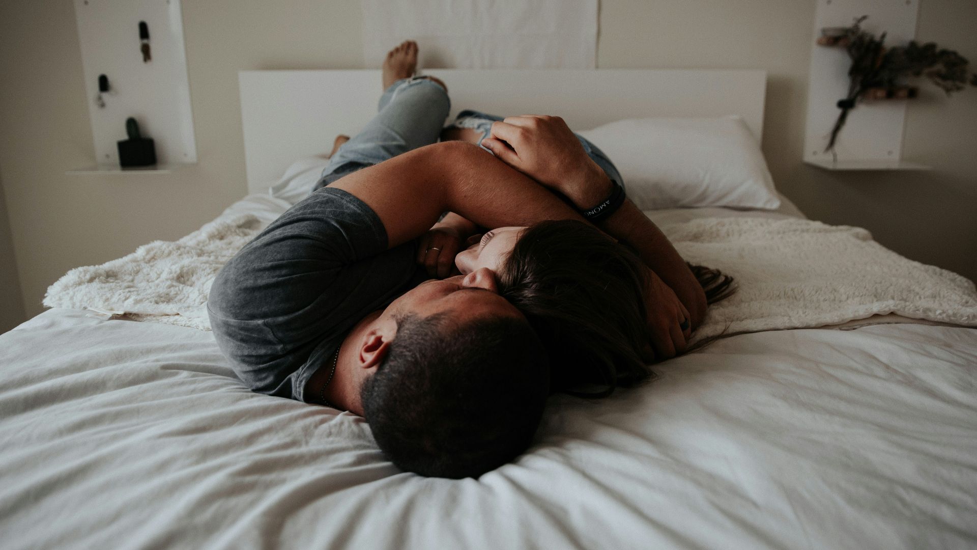 A man and woman cuddling together in bed.