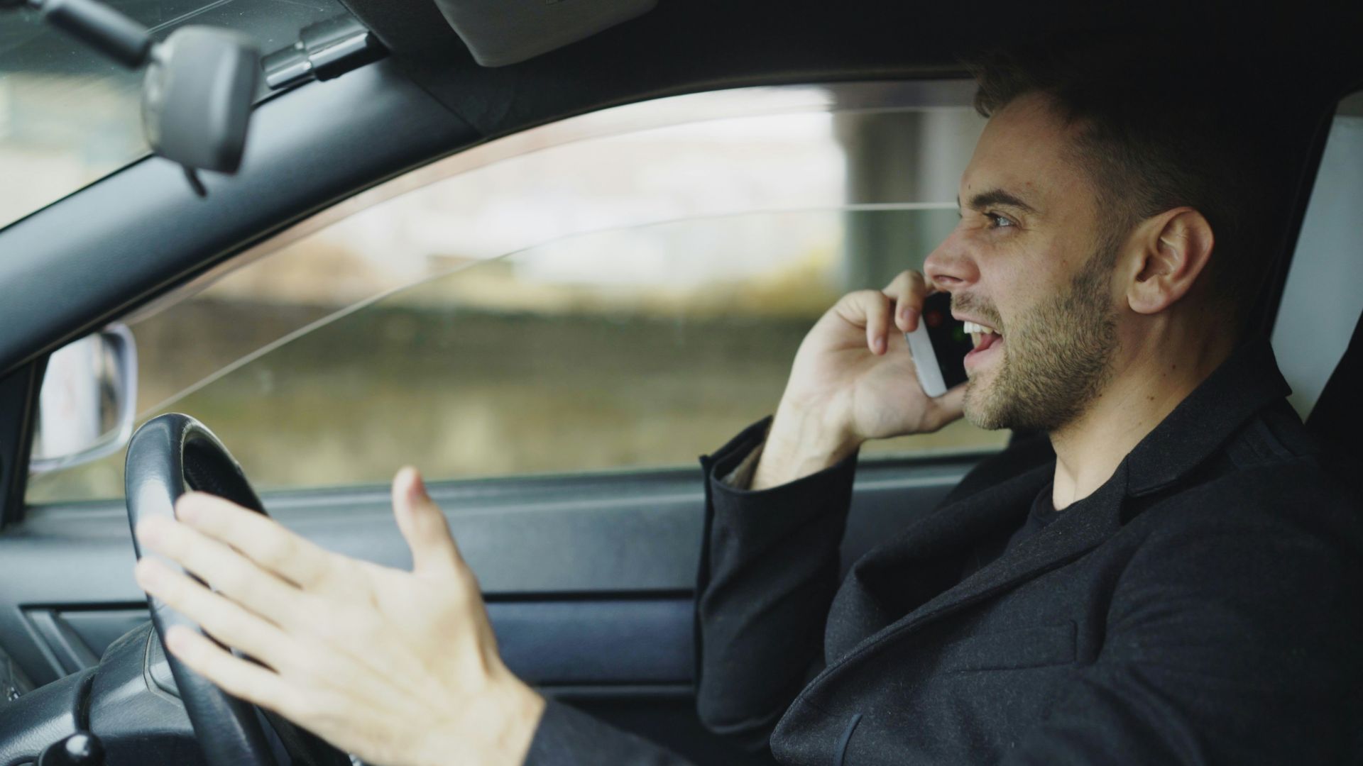 Man talking on phone while driving car