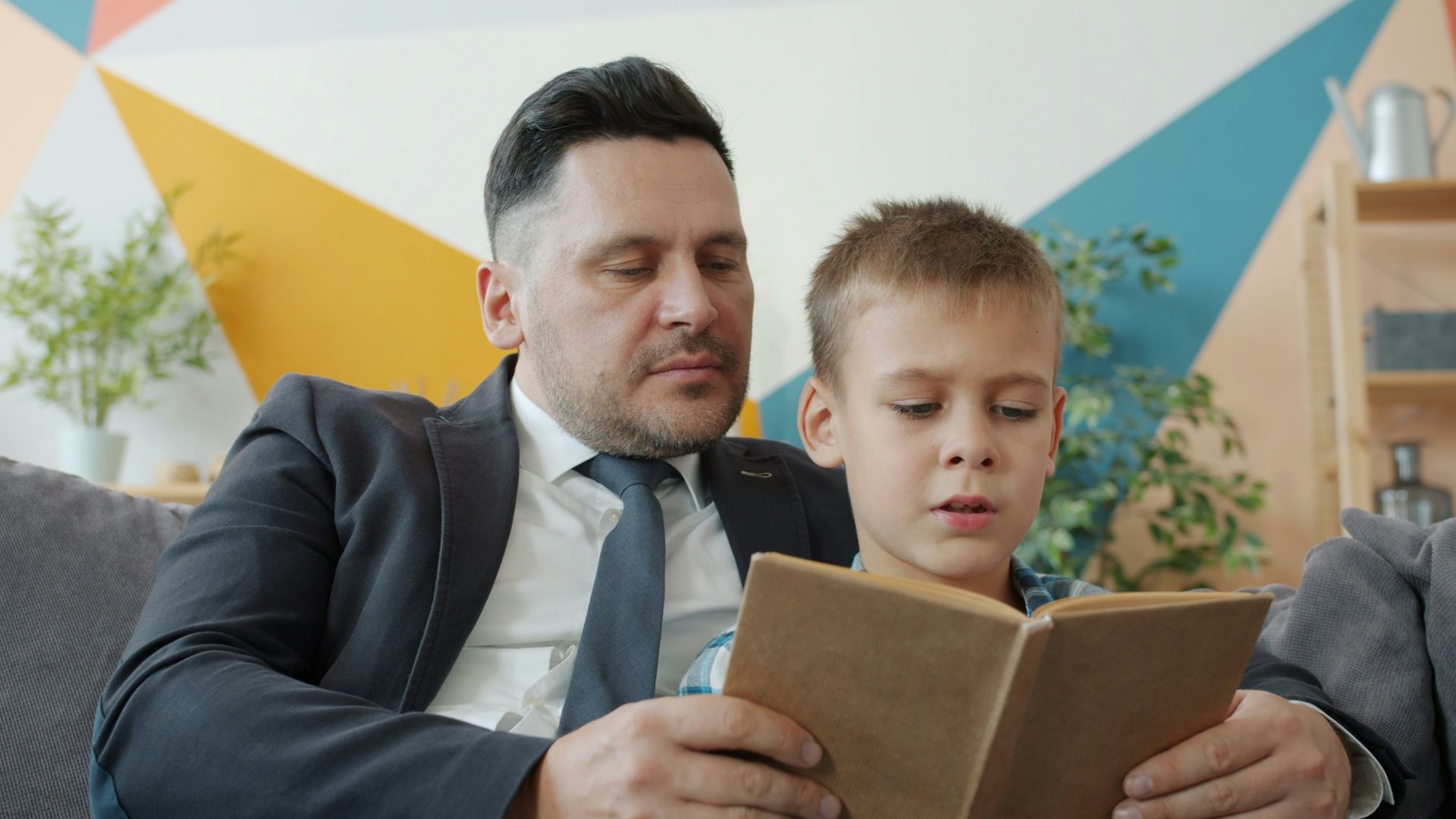 Father and son reading a book together