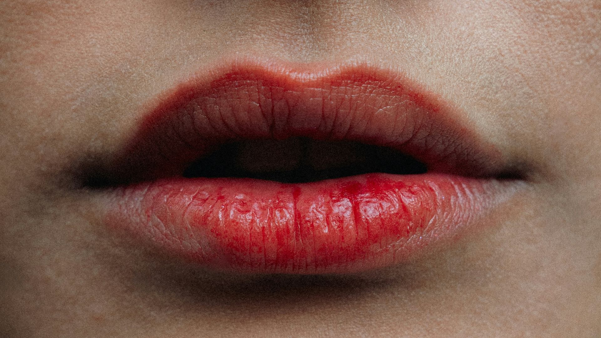Close-up of a woman's red lips and nose