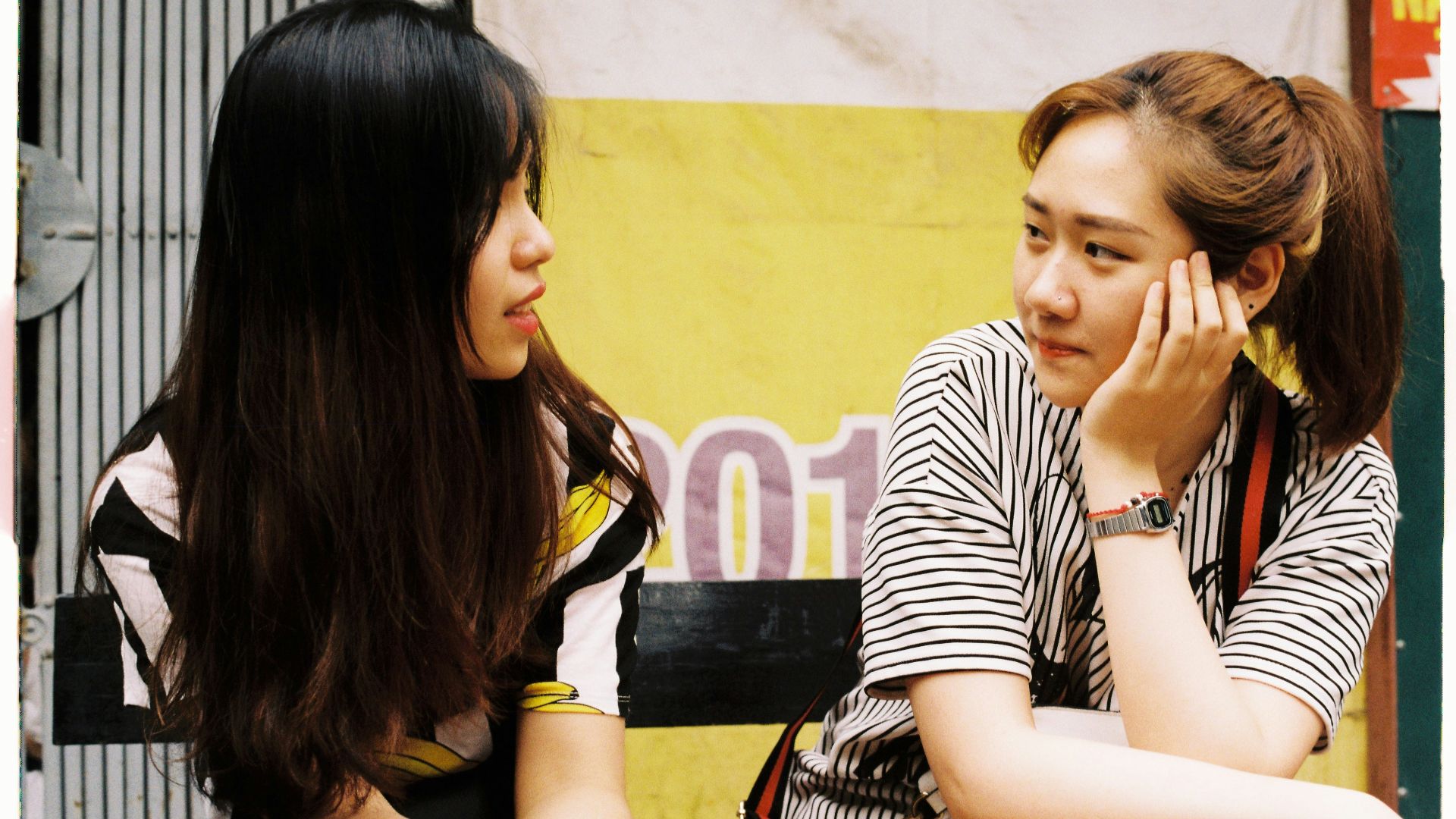 woman in white-and-black striped tops looking each other
