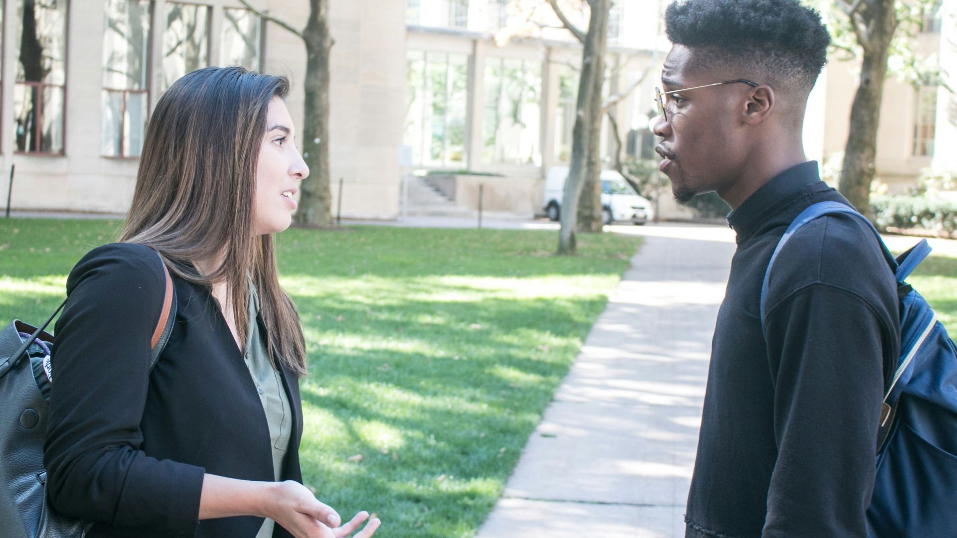 a man standing next to a woman on a sidewalk