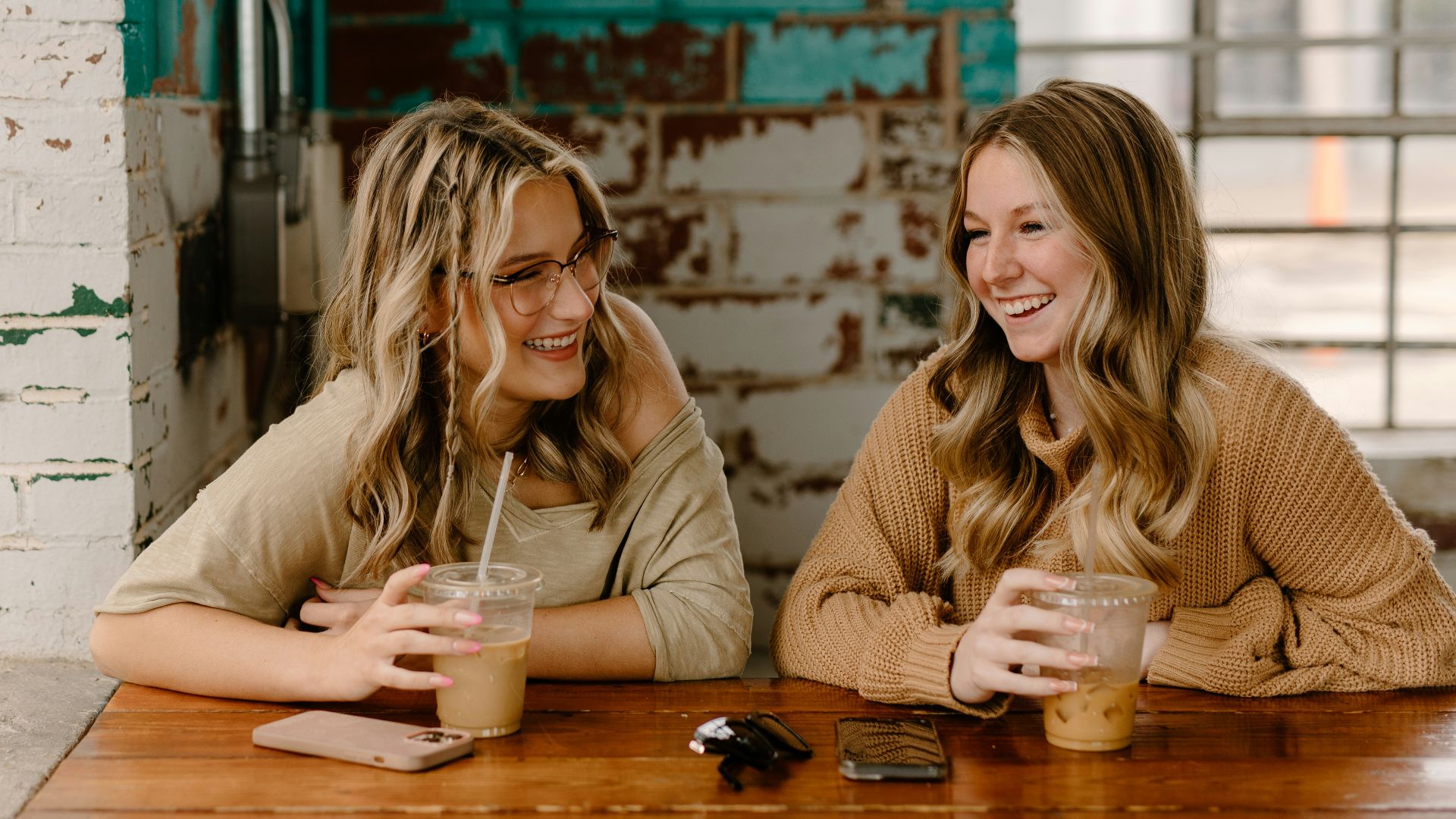 two women sitting at a table with drinks