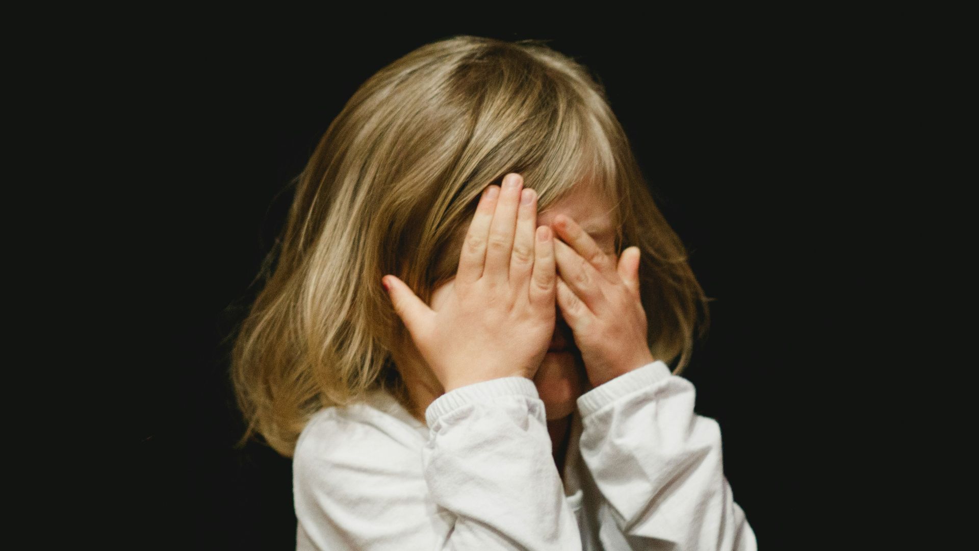 girl covering her face with both hands