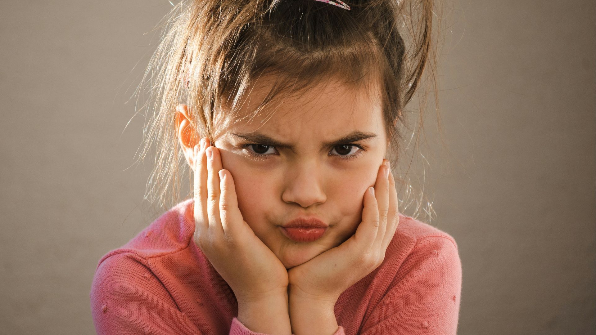 a young girl with her hands on her face