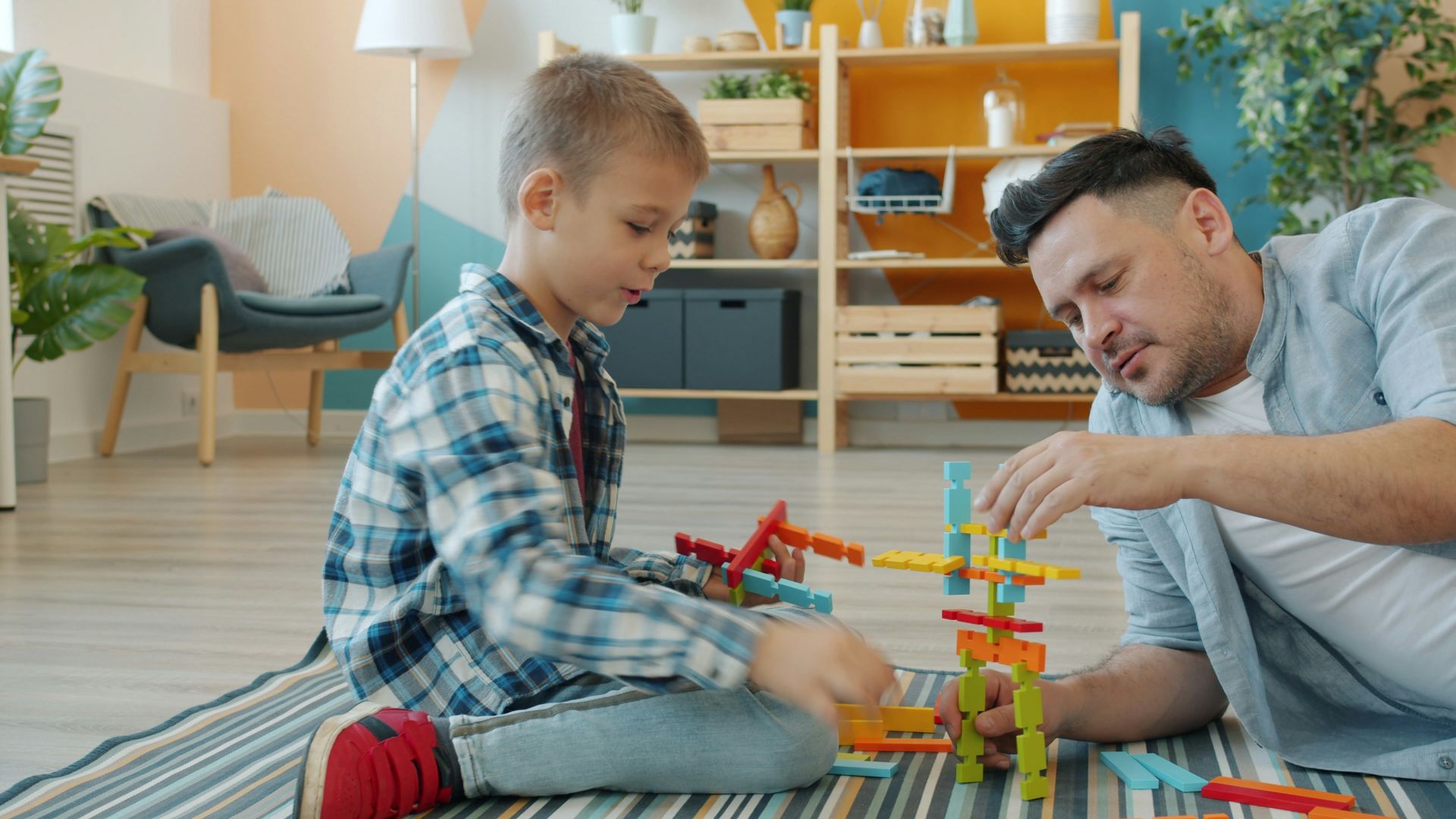 Father and son building with colorful blocks together.