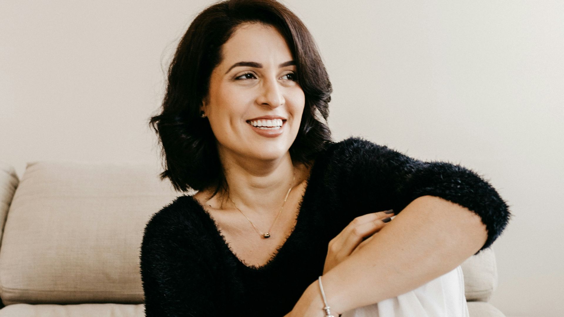 woman in black long sleeve shirt sitting on white couch