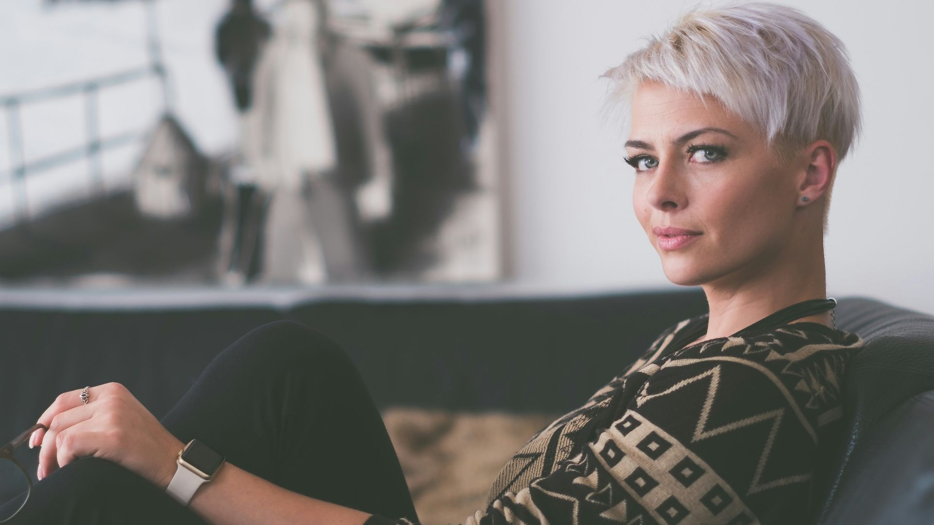 woman sitting on sofa holding eyeglasses