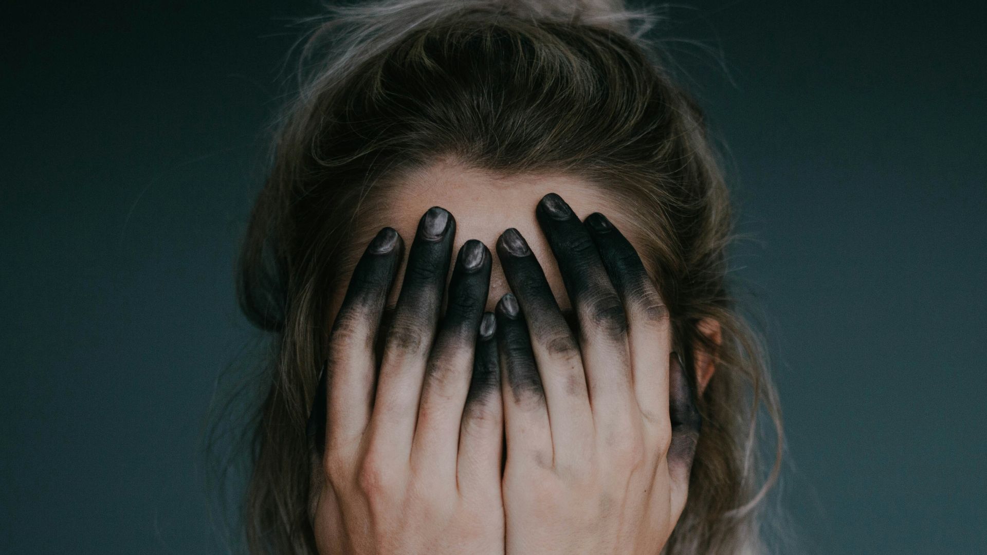 woman covering face with both hands closeup photography