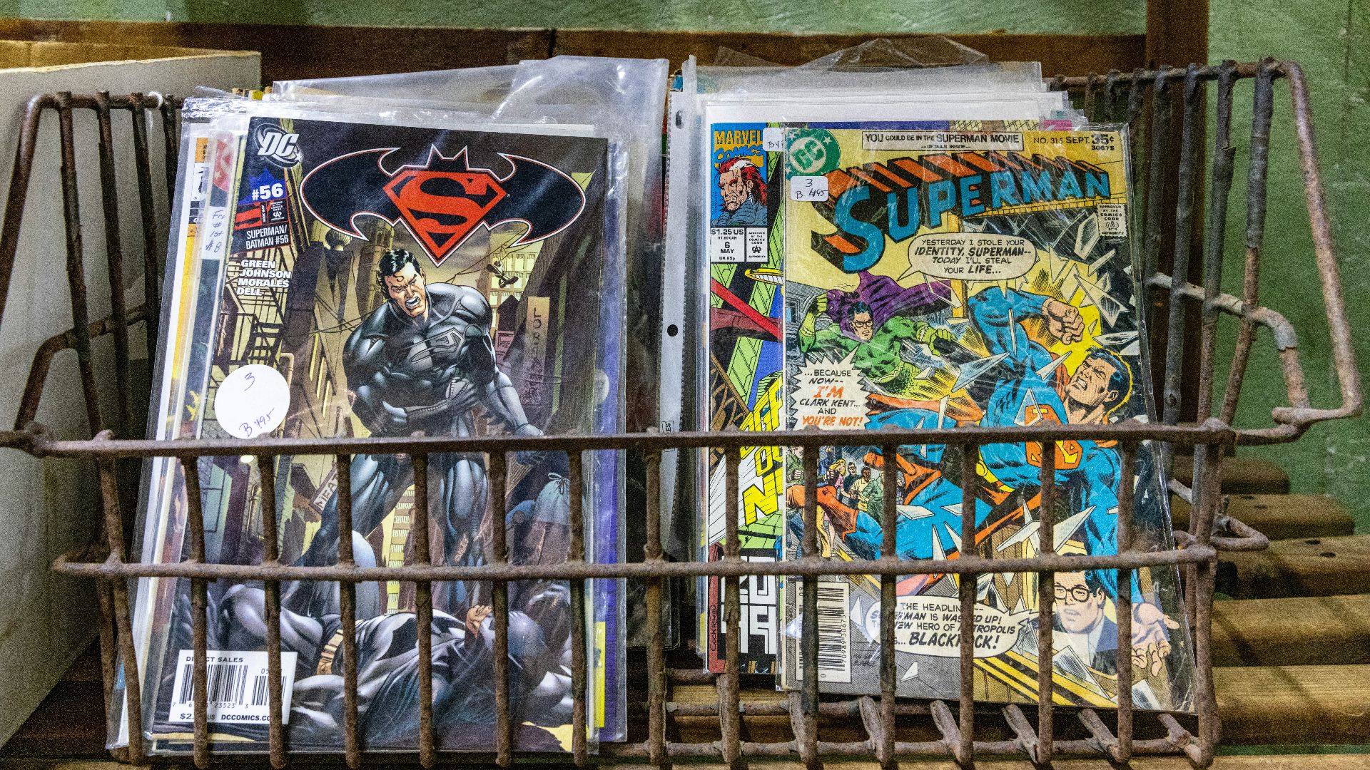 a metal basket filled with comic books on top of a table
