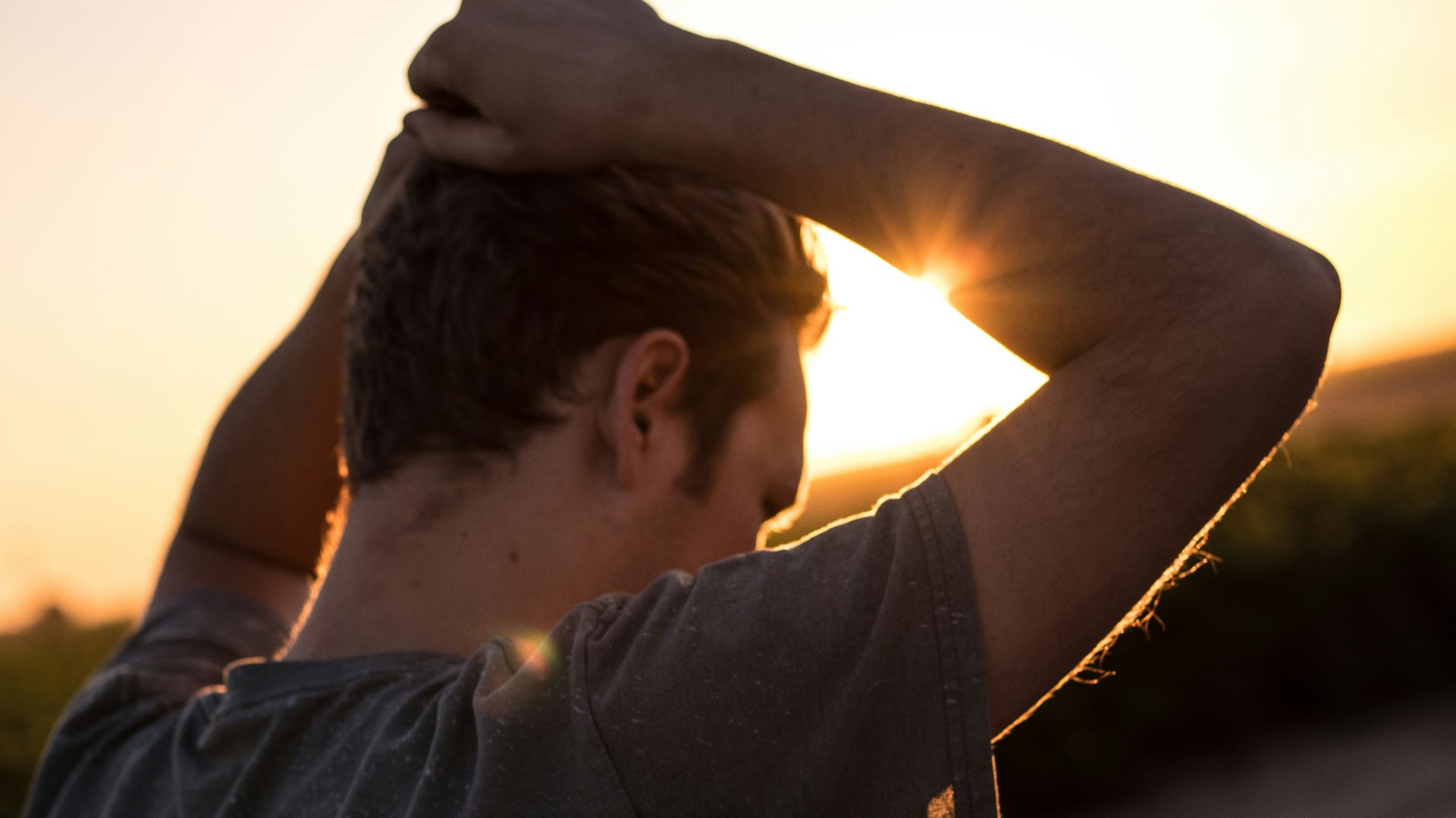 man holding his hair against sunlight