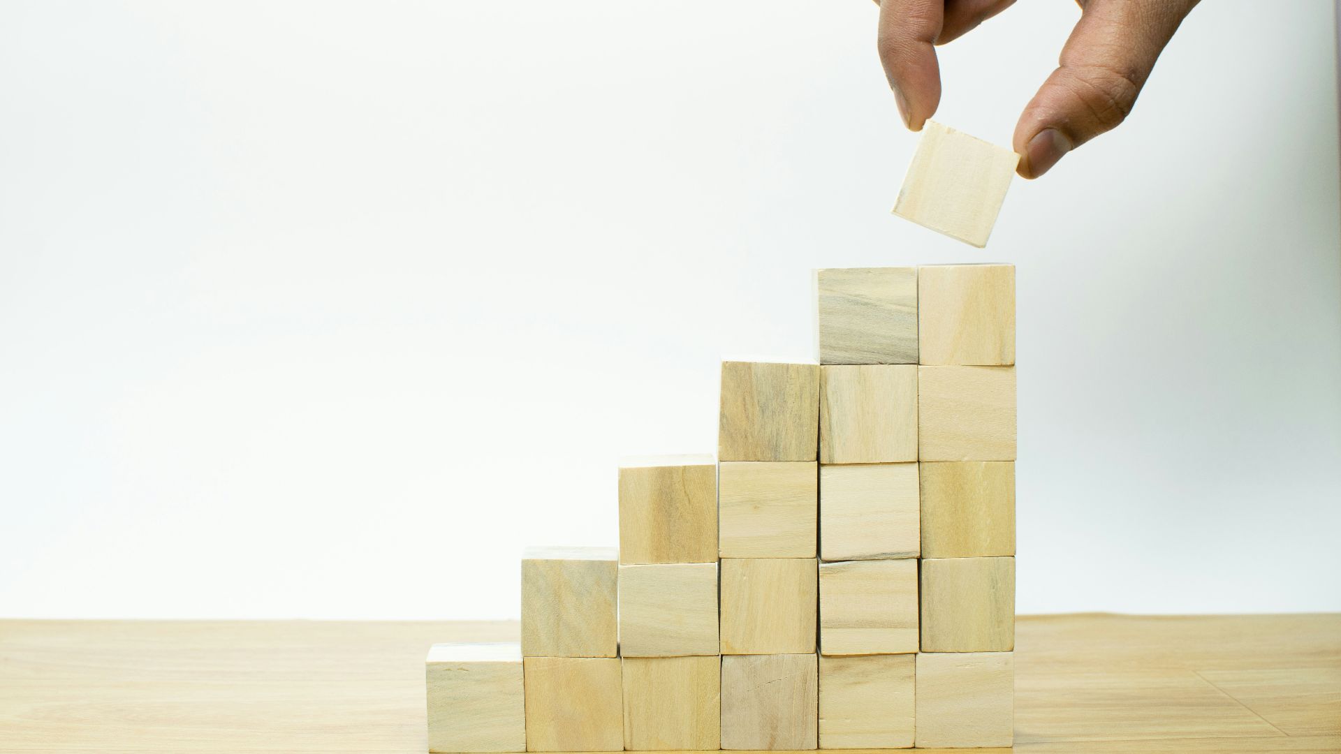 A person placing a piece of wood into a pyramid