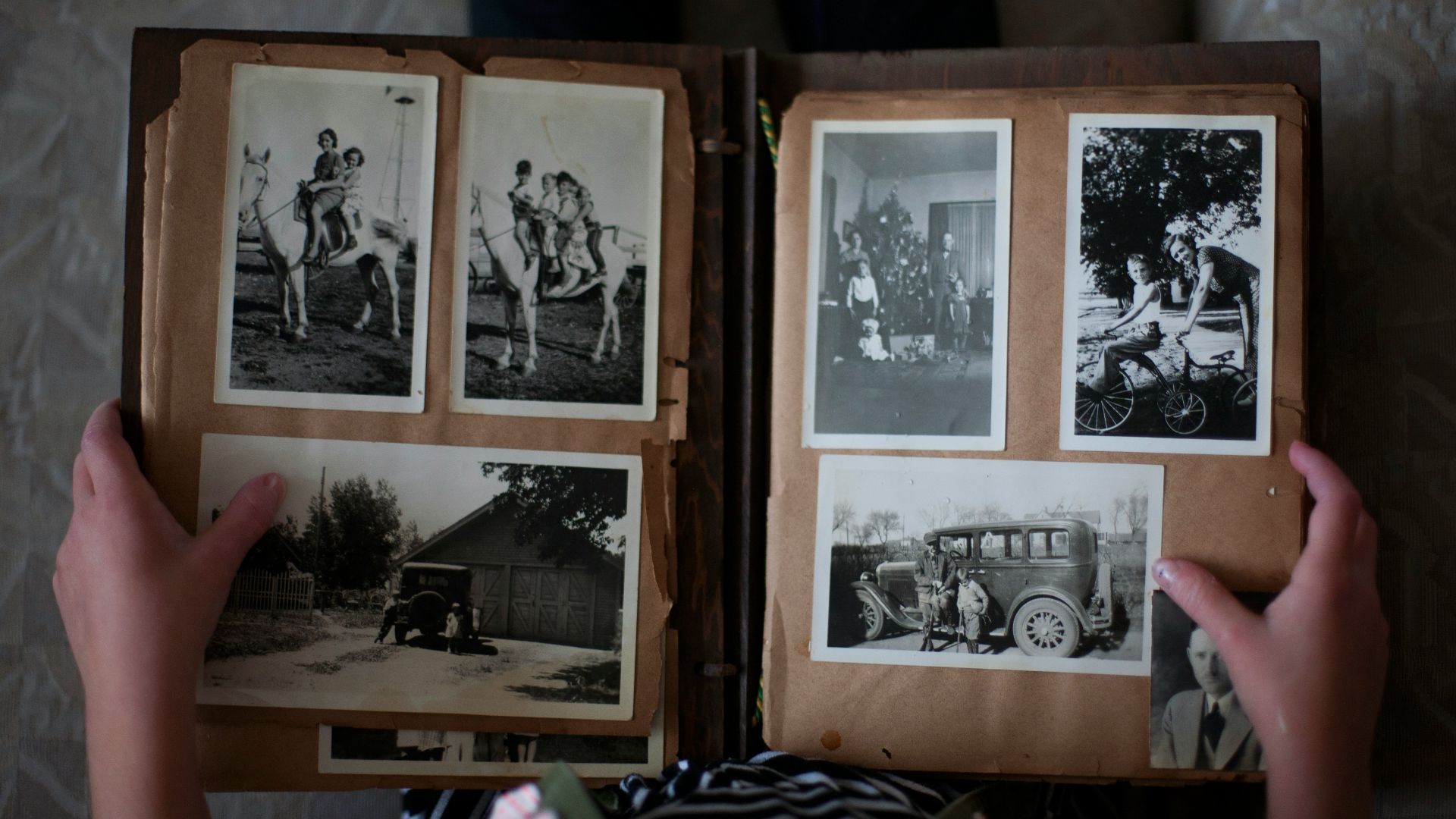 person opening photo album displaying grayscale photos