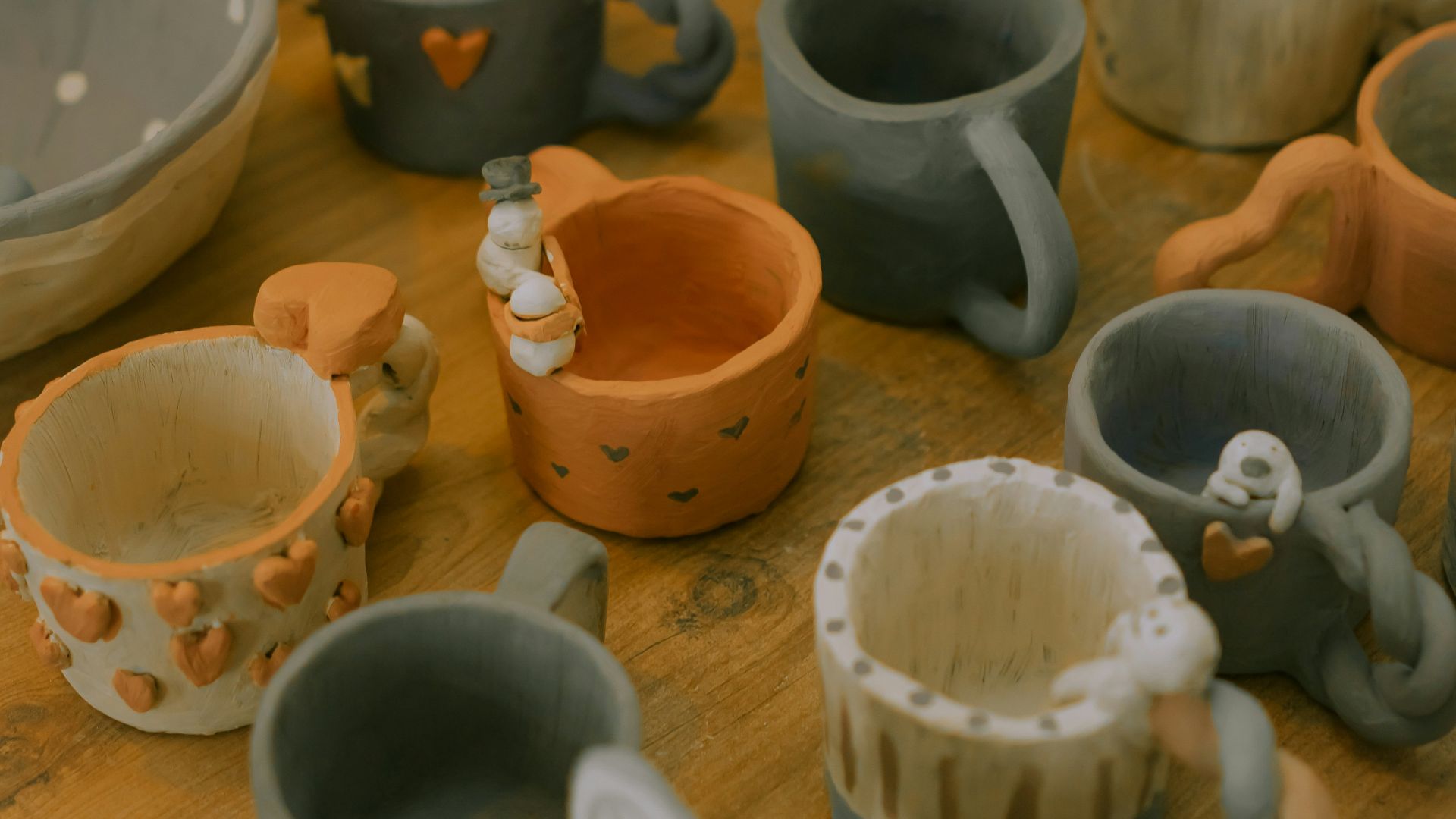 a wooden table topped with lots of ceramic cups