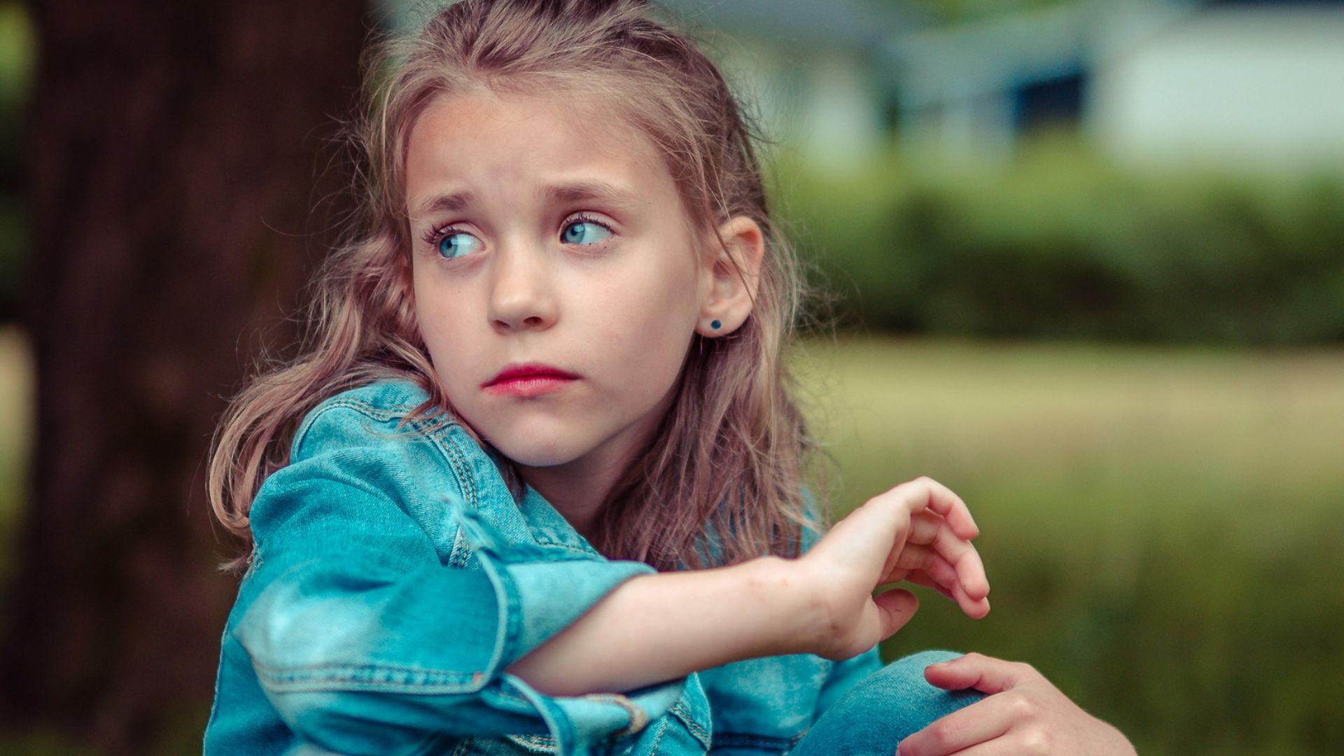 selective focus photography of girl sitting near tree