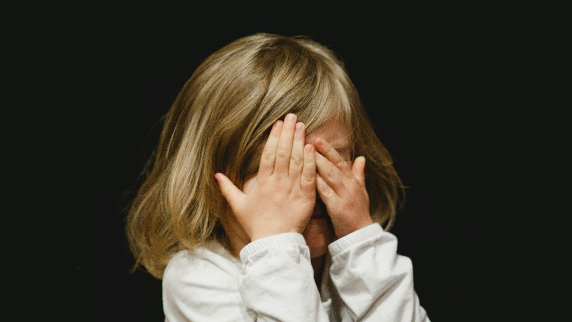 girl covering her face with both hands