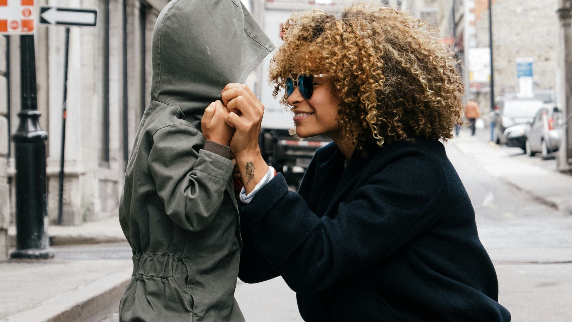 woman holding kid at the street
