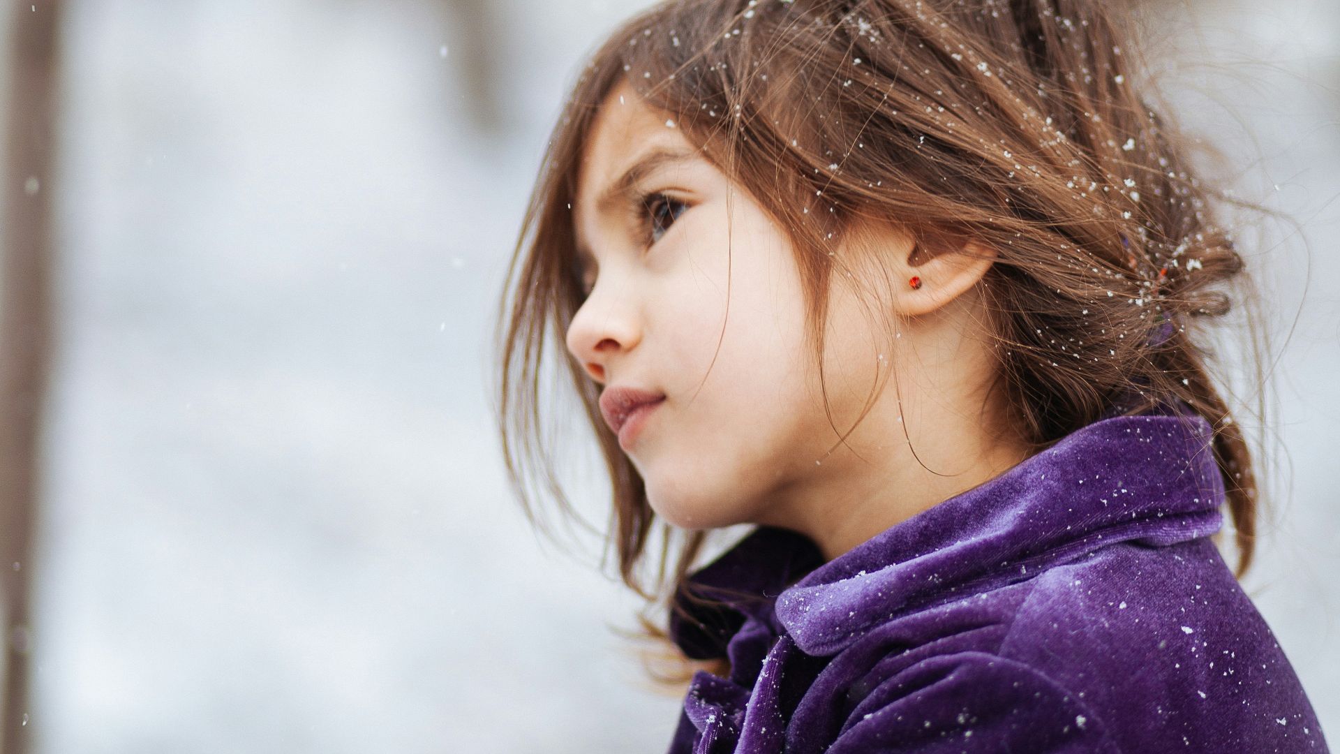 girl wearing purple jacket across blurry background