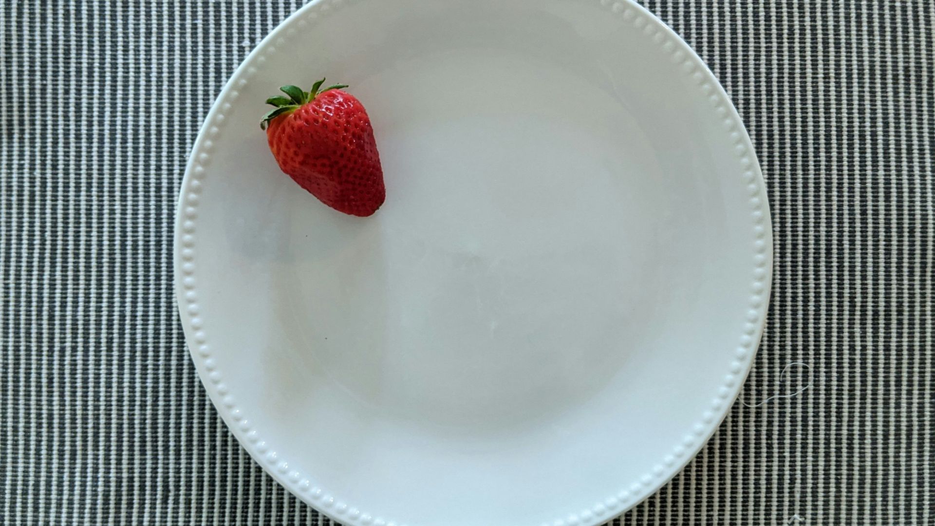red strawberry on white ceramic plate